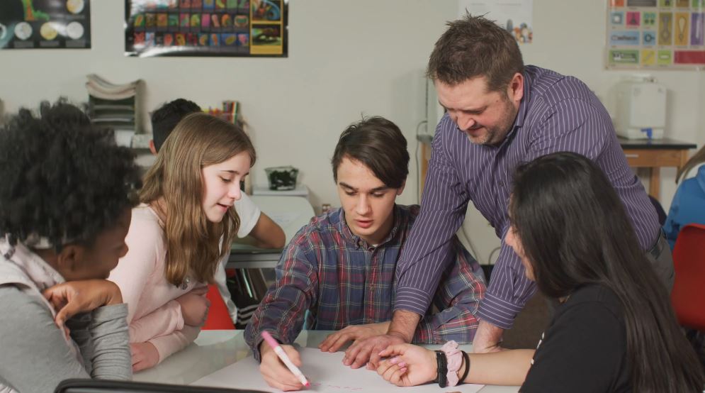 Image of teacher working with students